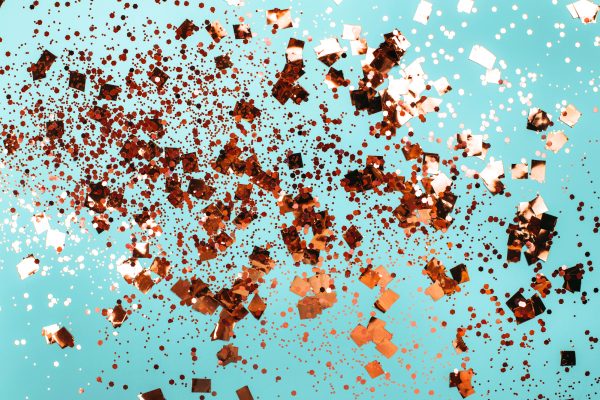 Falling silver confetti on bluebackdrop. Falling silver confetti on blue backdrop. Holiday concept.